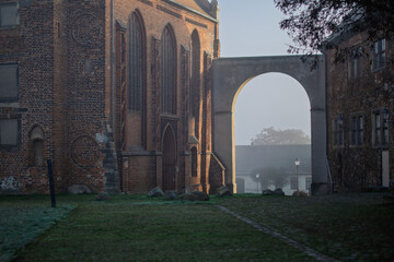 Historic Red Brick Church Facade and Archway in Wolmirstedt on a Hazy Morning