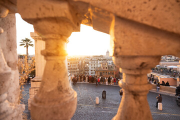 Festive city view in Rome seen through historic stone balustrade at sunset. Warm winter light, holiday atmosphere, city break tourism, celebration, inspiration and European urban lifestyle concept.