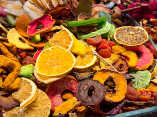 Assorted dried fruit slices with citrus rings and apple pieces forming a vibrant mixture in Istanbul bazaar. Natural dehydration, tea ingredients, and decorative food styling highlighted through color