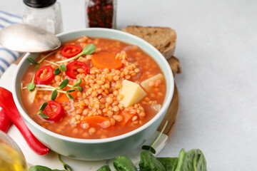 Delicious lentil soup with vegetables served on light grey table, closeup. Space for text
