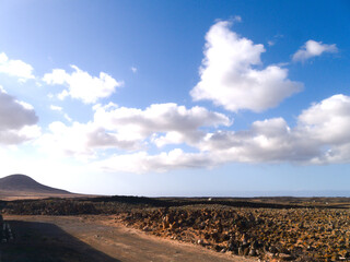 El Cotillo village - Fuerteventura island - Spain - December 4 2025 : Beautiful view of arid desert landscape. Dramatic barren terrain with mountains and blue sky.