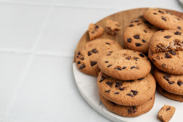 Delicious chocolate chip cookies on light table, closeup. Space for text