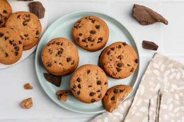 Delicious chocolate chip cookies on light table, flat lay
