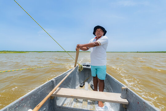 Fisherman standing on a boat in a calm sea
