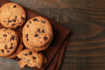 Yummy chocolate chip cookies on wooden table, top view. Space for text
