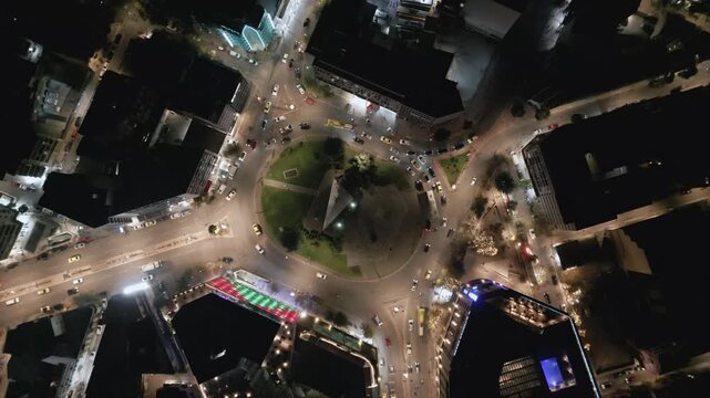Aerial top down view of night traffic on a circular road in Metaxourgio district, Athens, Greece. Cars moving in light trails create an urban city pattern