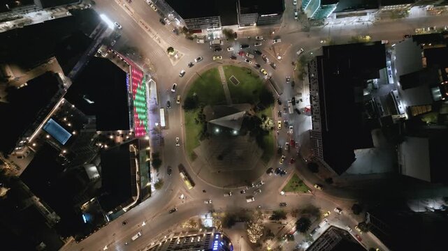 Aerial top down view of night traffic on a circular road in Metaxourgio district, Athens, Greece. Cars moving in light trails create an urban city pattern