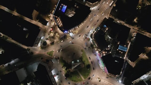 Aerial top down view of night traffic on a circular road in Metaxourgio district, Athens, Greece. Cars moving in light trails create an urban city pattern