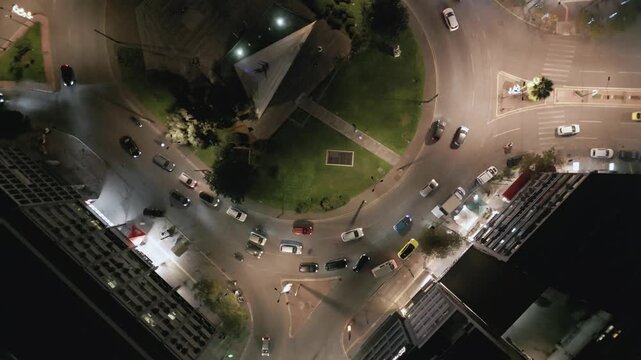 Aerial top down view of night traffic on a circular road in Metaxourgio district, Athens, Greece. Cars moving in light trails create an urban city pattern