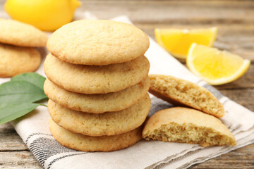Tasty lemon cookies and fruit slices on wooden table, closeup