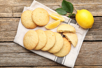 Tasty lemon cookies and fruit slices on wooden table, flat lay