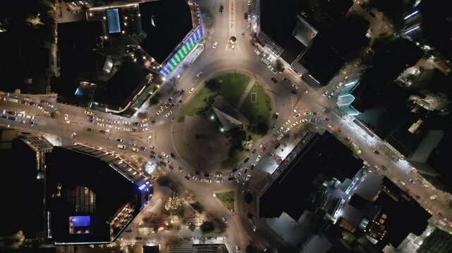 Aerial top down view of night traffic on a circular road in Metaxourgio district, Athens, Greece. Cars moving in light trails create an urban city pattern