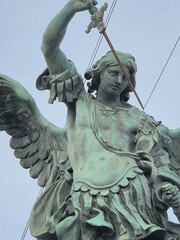 Rome, Italy - 12 January 2025. Detailed view of bronze Archangel Michael statue at Castel Sant'Angelo, showing sword, wing, and flowing garment features.