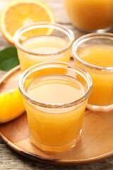 Fresh orange juice and fruits on wooden table, closeup