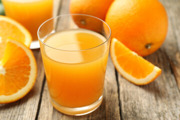 Fresh orange juice and fruits on wooden table, closeup