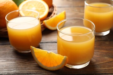 Fresh orange juice and fruits on wooden table, closeup