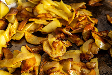 Potatoes are fried in a pan. Delicious, golden slices of potatoes are cooked in butter. The process of cooking the dish