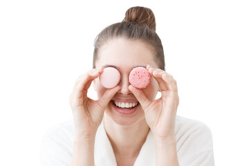 Girl holding colorful macarons in front of eyes, having much fun, feeling excited