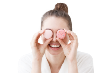 Girl holding colorful macarons in front of eyes, having much fun, feeling excited