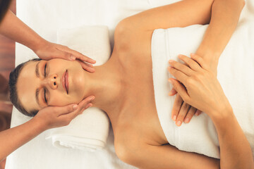 Panorama top view of woman enjoying relaxing anti-stress head massage and pampering facial beauty skin recreation leisure in dayspa modern light ambient at luxury resort or hotel spa salon. Quiescent