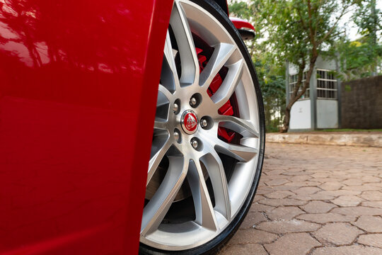 Red Jaguar F-Type alloy wheel close up, brake caliper and rim of luxury sportscar
