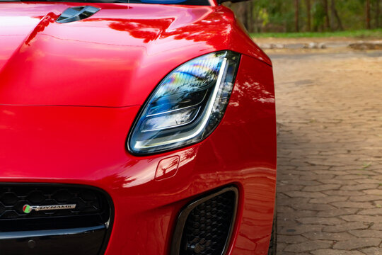 Red Jaguar F-Type headlight detail, led daytime running light of luxury sportscar