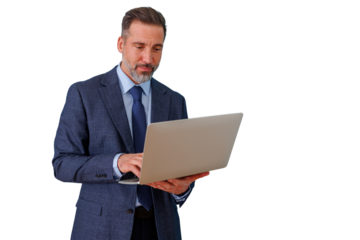 Mature businessman in suit and tie standing, working on laptop, focusing on online business and remote communication