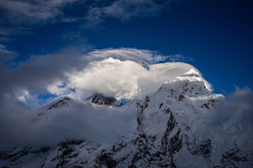Mt. Everest, or Chomolungma, and peaks nearby, hidden in clouds. Evening view from Kala Patthar slope over Gorak Shep, the end of Everest base  camp trek in Nepal.