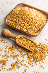 Golden linseed or flaxseed. Healthy flax seed in wooden scoop on kitchen table.