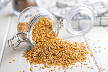 Golden linseed or flaxseed. Healthy flax seed in jar on white table.
