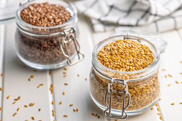 Golden linseed or flaxseed. Healthy flax seed in jar on white table.