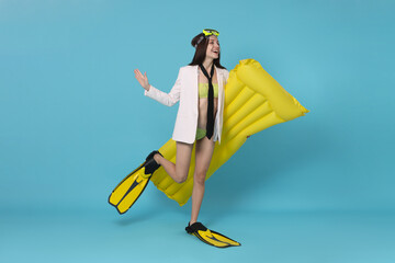 Businesswoman with diving mask, air mattress and flippers on light blue background © New Africa