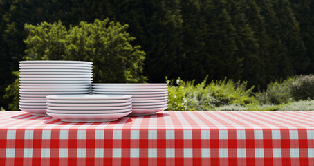 Empty red and white checkered tablecloth for picnic over green background 