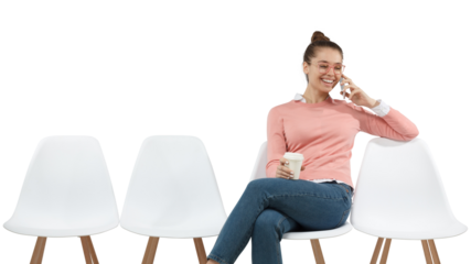 Smiling female student sitting in the line with coffee cup, glad to hear boyfriend over phone