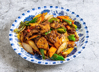 Delicious stir-fried meat and vegetables in a blue and white bowl