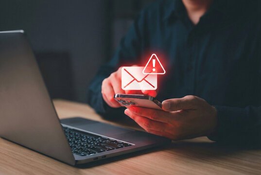 Concept of phishing scam, cyber threat, email fraud, and online security. Warning spam email alert on smartphone and laptop. cybersecurity risks to protect digital identity from hacker - Powered by Adobe