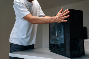 Closeup of computer technician removing side panel of desktop computer, accessing internal components for diagnostic maintenance at professional workplace. Concept of service, repair and cleaning PC.