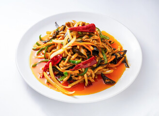 Spicy stir fried noodles with vegetables and chili peppers on a white plate