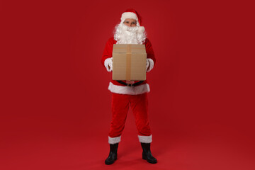 Santa Claus with parcel on red background