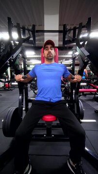 Front View of Athlete Using Plate-Loaded Chest Press Machine &ndash; Vertical Gym Workout