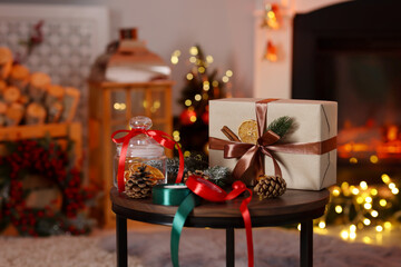 Christmas gift and festive decor on wooden table indoors, space for text. Bokeh effect