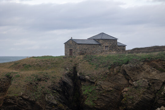 Stone chapel on cliff overlooking wild sea