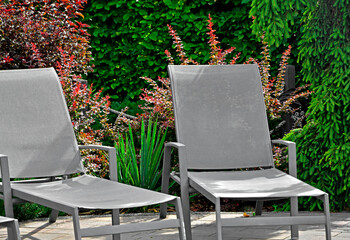 szary leżak w ogrodzie, leżak ogrodowy, puste leżaki ogrodowe, gray deckchair in the garden, garden deckchair, empty garden sunbeds, sitting area