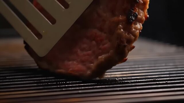 Burger patty sizzling on hot grill grates with char marks and rising steam, close-up shot evoking backyard barbecue, summer cookout, juicy grilled meat aroma
