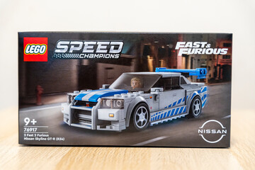 Naklejka premium Warsaw, Poland - Dec 16, 2025: A LEGO box displaying the Speed Champions Nissan Skyline GT-R from Fast & Furious, aimed at children aged 9+, set against a soft background.