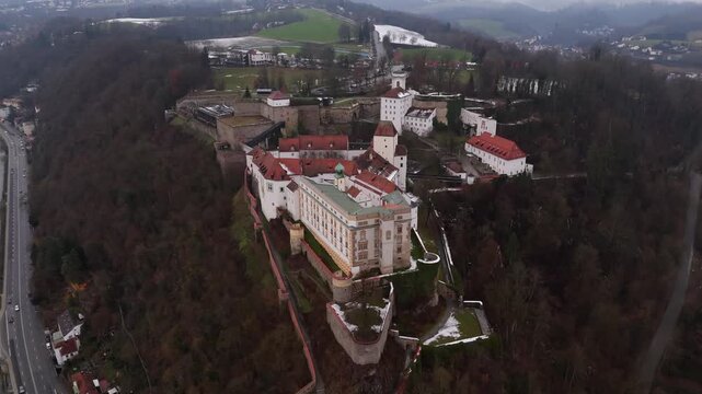 Luftbild der Veste Oberhaus auf dem St. Georgsberg in Passau, Deutschland. Die Aufnahme zeigt Veste Niederhaus, den Wehrgang und die drei Fluesse Donau, Inn und Ilz unter bedecktem Winterhimmel.