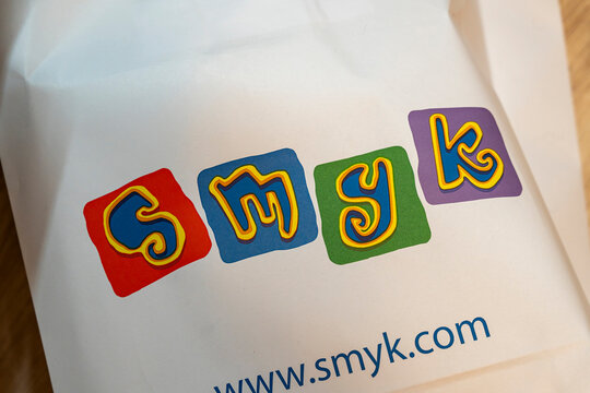 Warsaw, Poland - Dec 16, 2025: Colorful SMYK logo displayed on a shopping bag, expressing playful design and branding. Perfect for marketing and retail purposes.