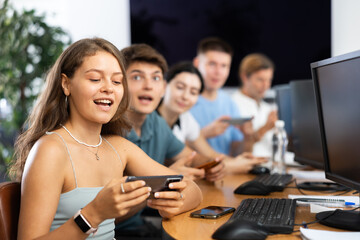 Student are engrossed in their mobile phones, working diligently on their tasks.