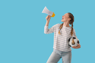 Female soccer fan with ball shouting into megaphone on blue background