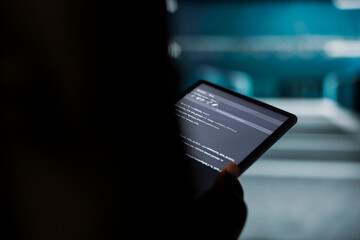 Close up of data center engineer conducting tests on equipment using tablet software to fix bugs. Server farm employee using device to refine algorithms for faster processing, updating core services